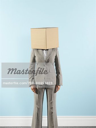 Femme d'affaires portant une boîte en carton sur la tête