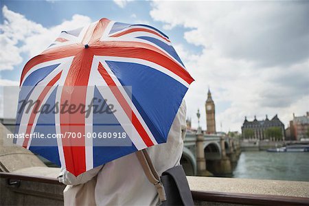 Tourists With Union Jack Umbrella Looking Over Westminster Bridge, London, England