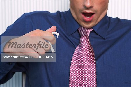 Close-up of Businessman holding Handle of Broken Mug