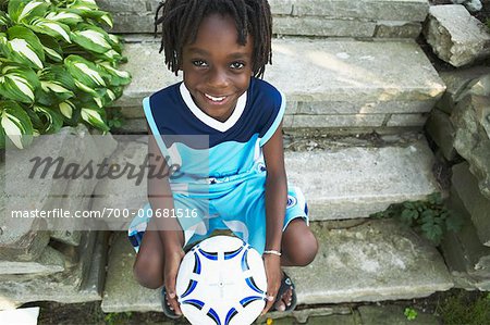 Boy Sitting On Steps Holding Ball