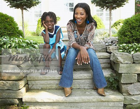 Mother and Son Sitting On Steps In Front Of House