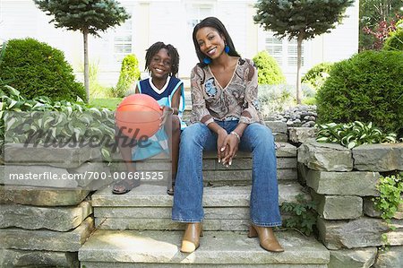 Mother and Son Sitting On Steps In Front Of House