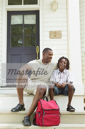 Father and Son Sitting On Steps Of House