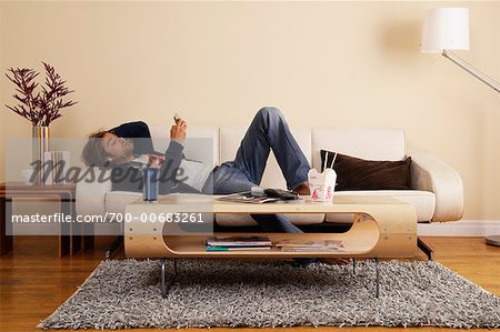Man Listening to MP3 Player on Sofa