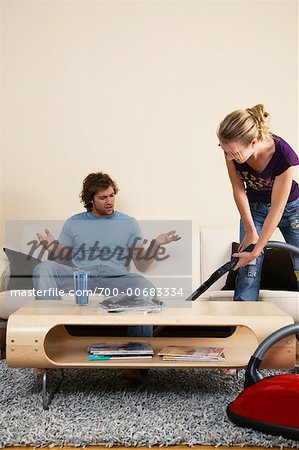 Man Annoyed with Woman Vacuuming