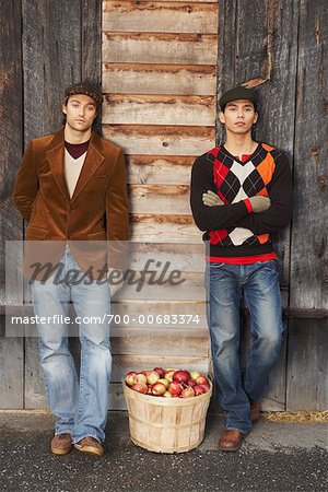 Portrait of Men Standing By Basket of Apples