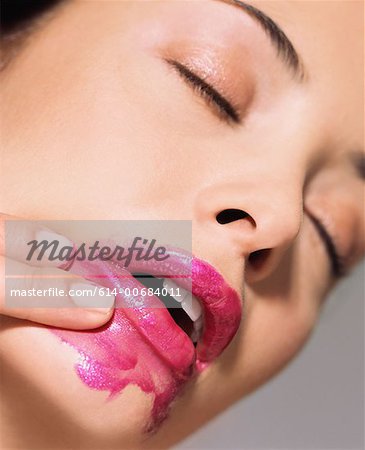 Woman smearing lipstick