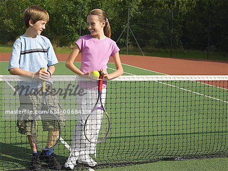 Mädchen und jungen in einen Tennisplatz