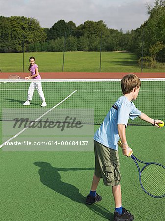 Brother and sister playing tennis