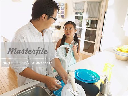 Homme et jeune fille lavant la vaisselle