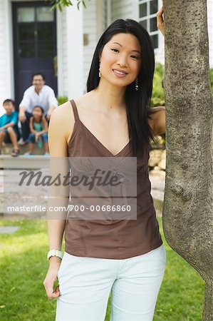 Porträt Frau mit Familie vor Haus