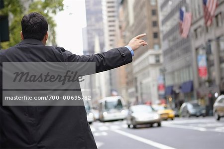 Homme d'affaires de héler un taxi, New York, New York, USA