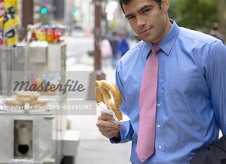 Businessman Eating Soft Pretzel, New York, New York, USA