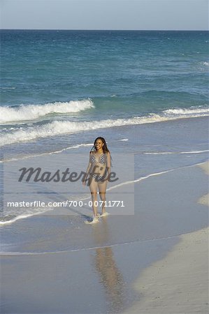 Femme qui marche le long de la plage à Cuba