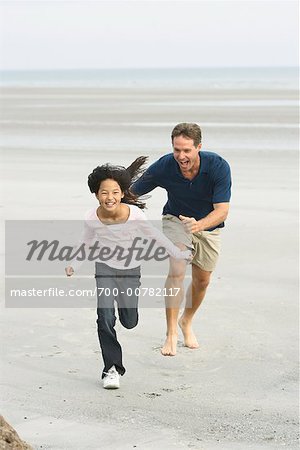 Vater und Tochter am Strand laufen