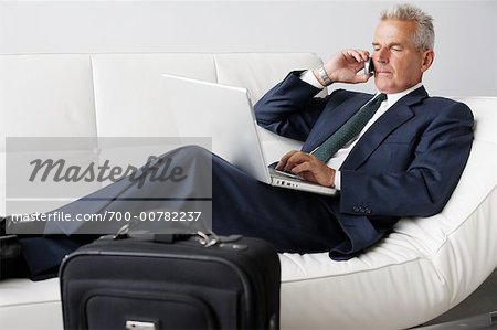Businessman on Cellular Phone Using Laptop