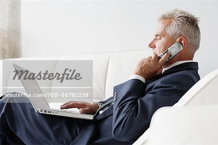 Businessman on Cellular Phone Using Laptop