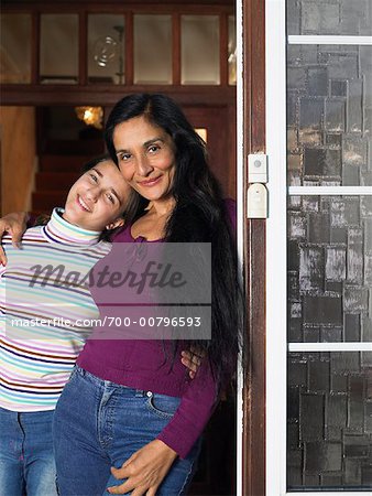 Mère et fille dans l'embrasure de la porte de la maison