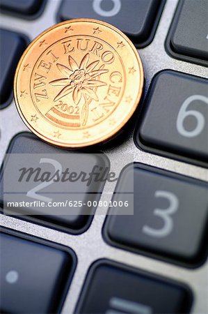 Gros plan d'une pièce de centimes d'euro sur calculatrice