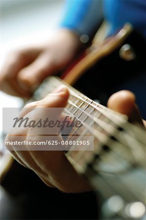 Close-up of man playing acoustic guitar