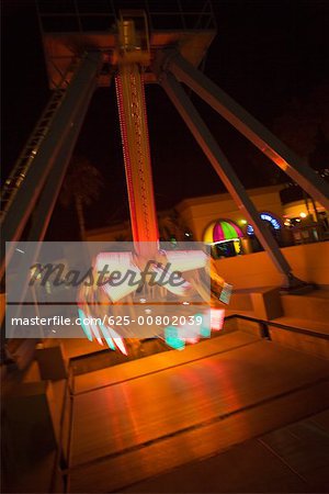 Lights glowing on a carnival ride at night, California, USA