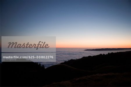 High angle view of clouds around a hill