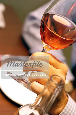 Close-up of a person's hand holding a glass of wine