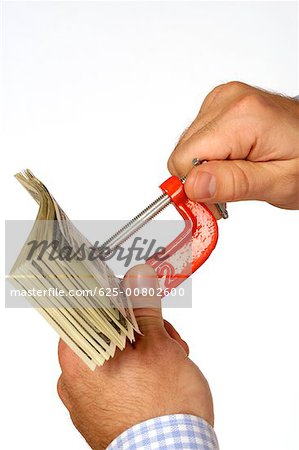 Gros plan de la main d'une personne tenant une poignée de l'étau avec le papier-monnaie