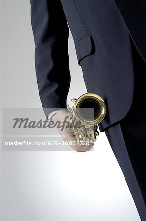 Mid section view of a man holding a trumpet