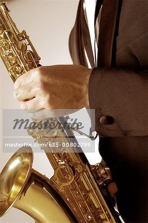 Mid section view of a musician playing the saxophone