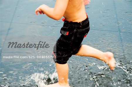 Low section view of a boy playing in water