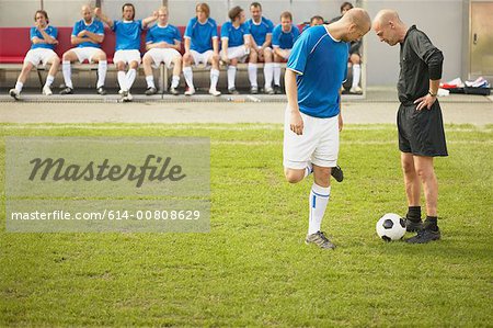 Referee talking to footballer