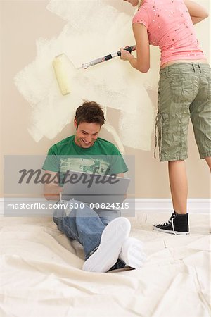 Homme sur ordinateur portable tandis que les peintures de femme