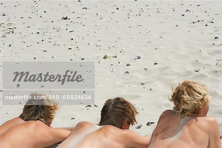 Jeune homme couché sur la plage