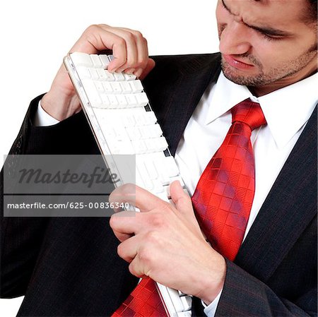 Nahaufnahme eines Kaufmanns hält eine Computertastatur in Frust