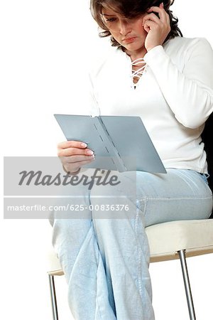 Businesswoman talking on a mobile phone and reading a diary
