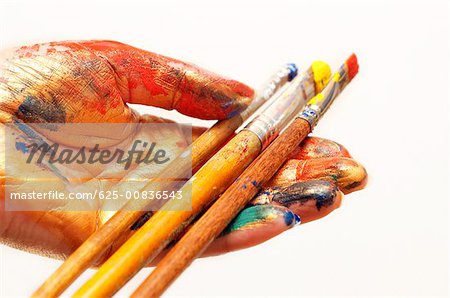 Close-up of paintbrushes in a person's hand