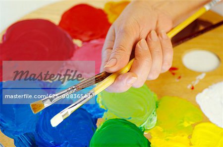 High angle view of a person's hand holding paintbrushes
