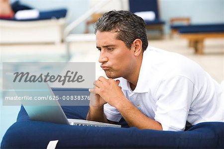 Gros plan d'un homme adult moyen à l'aide d'un ordinateur portable