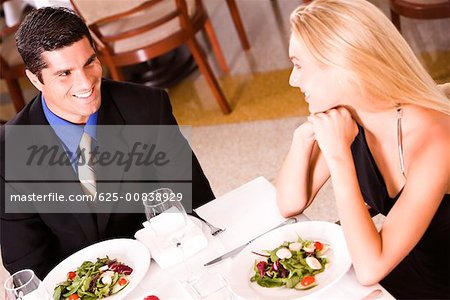 High angle view of a mid adult man and a young woman sitting at a table in a restaurant