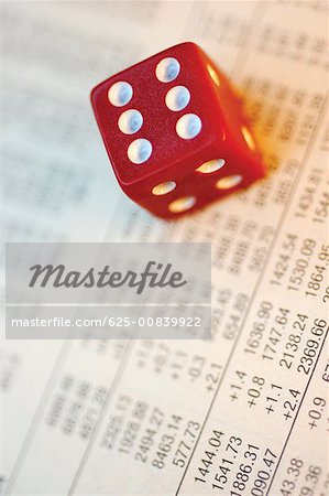 Close-up of a dice on a financial page