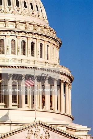 Low angle view of a flag fluttering on a government building, Capitol Building, Washington DC, USA