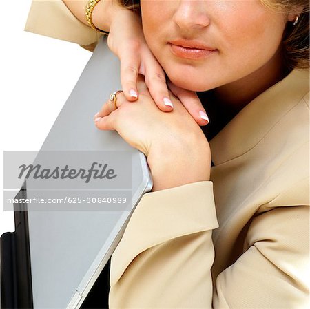 Close-up of a businesswoman leaning on a laptop