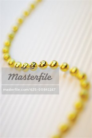 High angle view of a string of golden beads