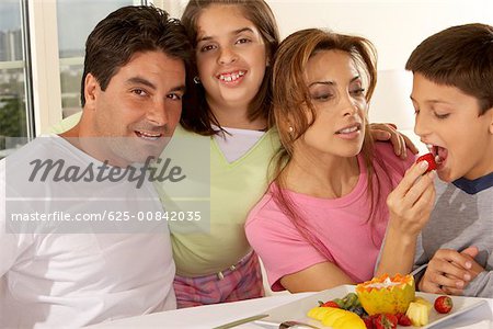 Mitte erwachsenen Mann mit seiner Tochter und mid Erwachsene Frau Fütterung ihres Sohnes eine Erdbeere