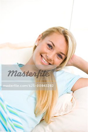 Portrait d'une jeune femme couchée sur un lit