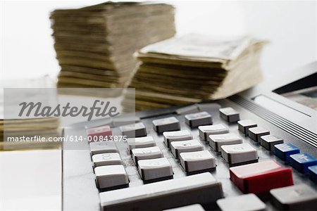 Calculator and stacks of banknotes