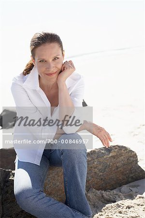 Frau sitzend auf einem Felsen
