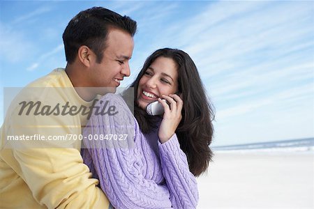 Man Hugging Woman Using Cell Phone