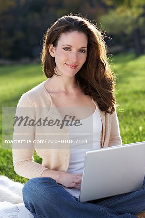 Femme à l'aide d'ordinateur portable à l'extérieur